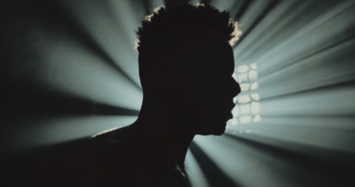 a silhouette of a man in front of a spotlight