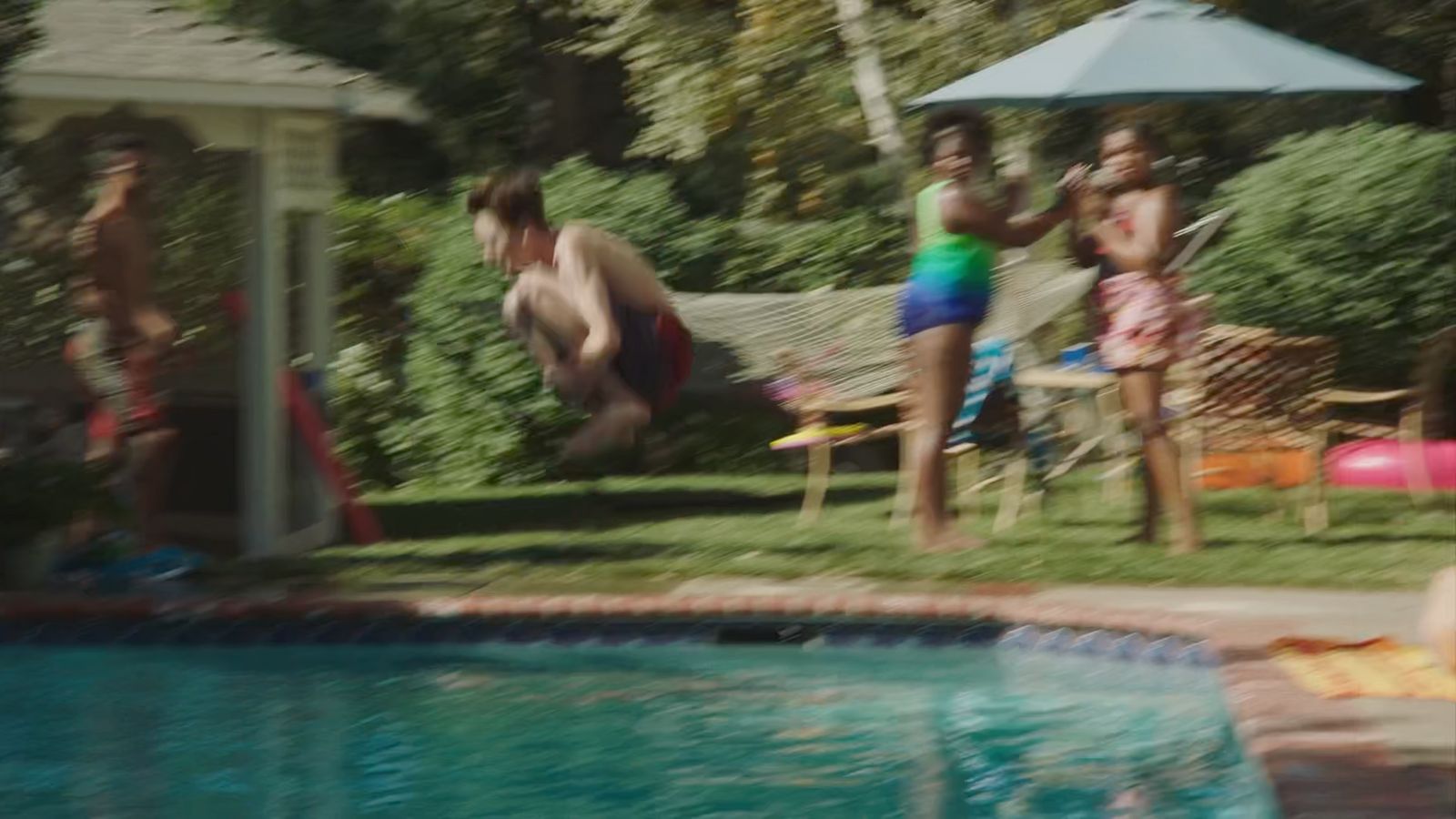 a group of people standing around a swimming pool