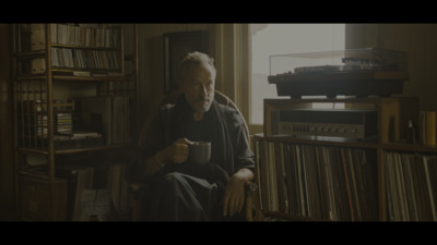 a man sitting in a chair holding a cup of coffee