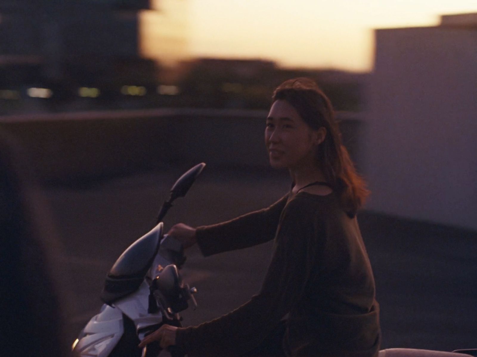 a woman riding a scooter on a city street