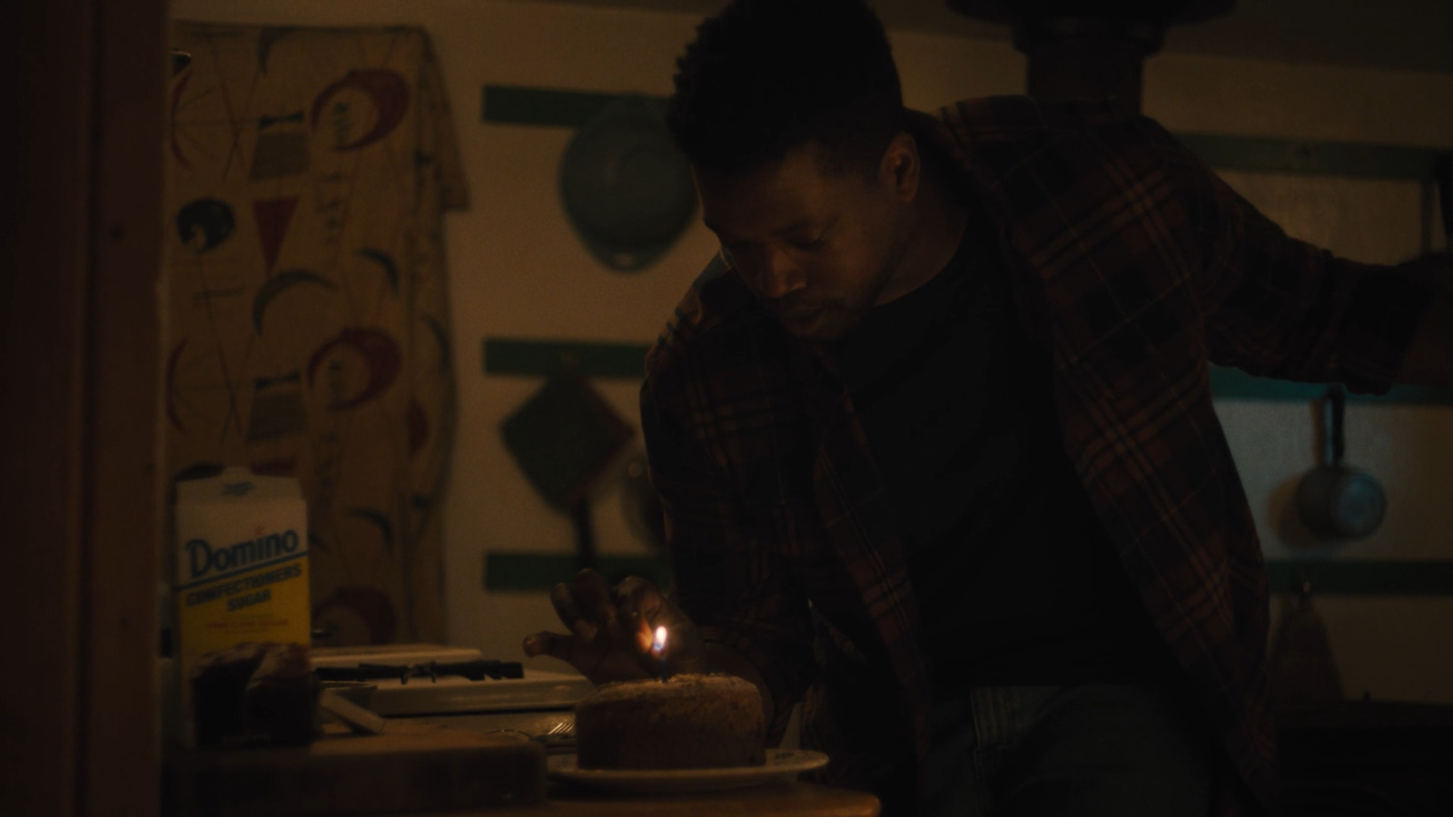 a man lighting a candle on a cake