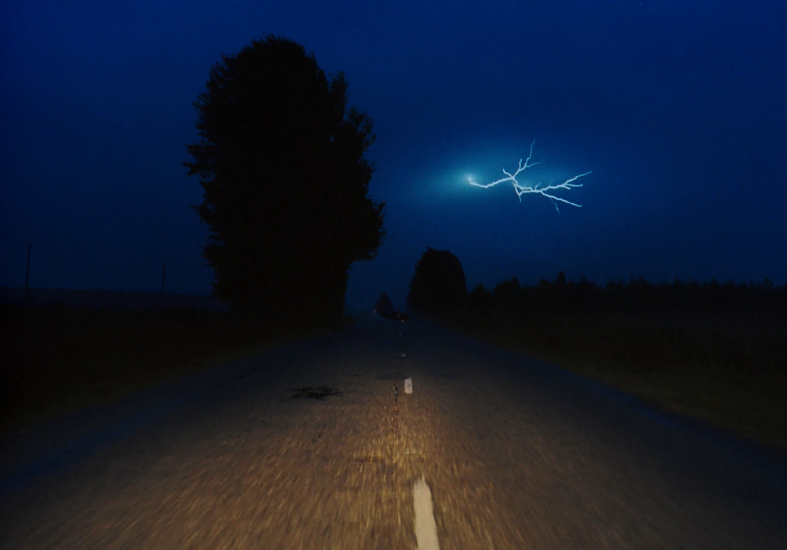 a car driving down a road at night