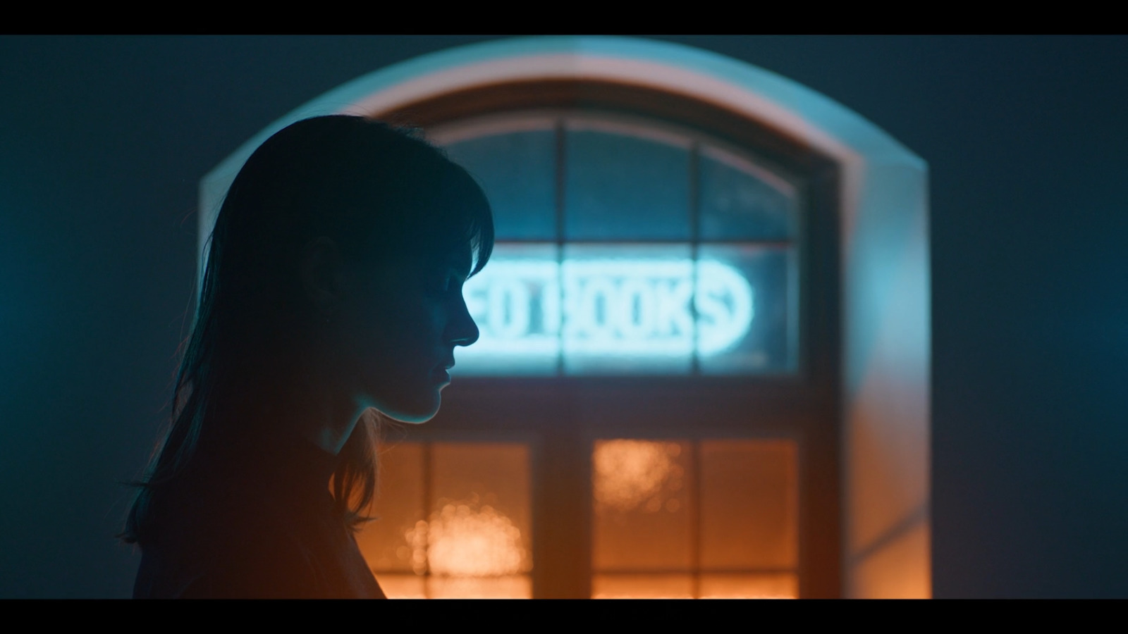 a woman standing in front of a building at night