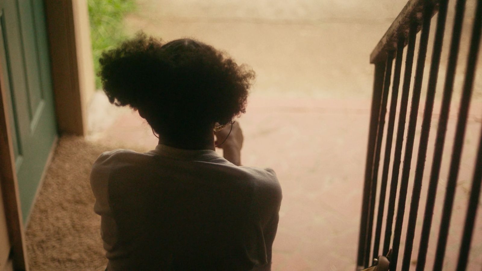 a woman talking on a cell phone while standing next to a gate