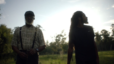 two men standing next to each other in a field