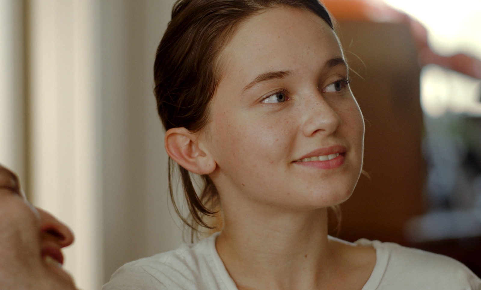 a woman with a white shirt and a man in the background