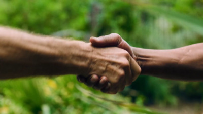 a close up of two people holding hands