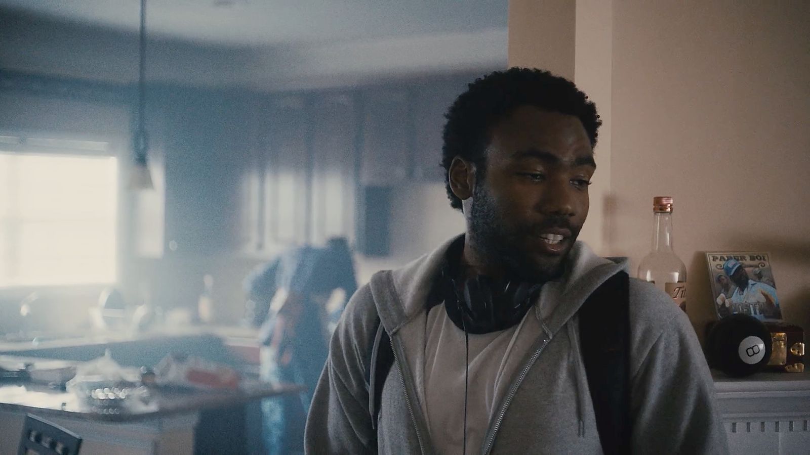 a man wearing headphones standing in a kitchen