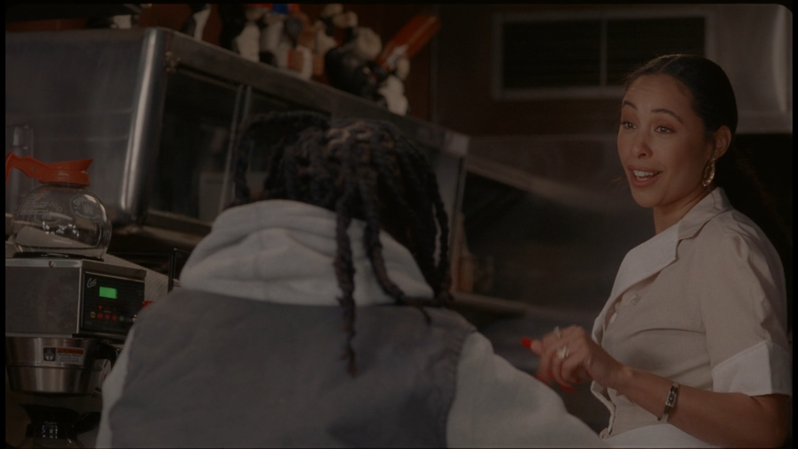 a woman with dreadlocks standing in front of a microwave