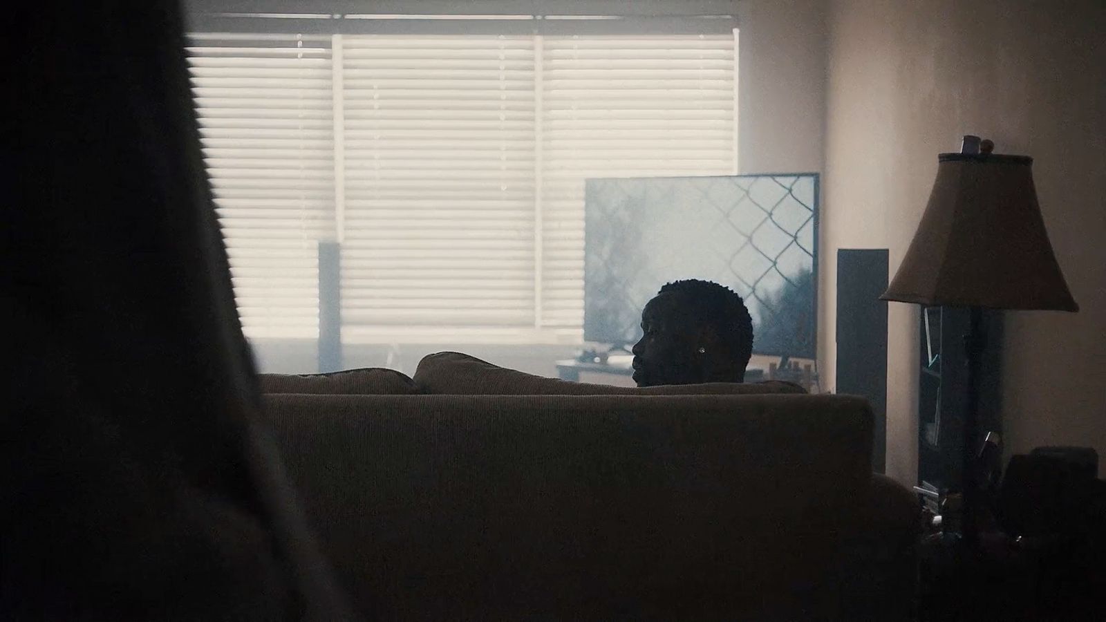 a person sitting on a couch in front of a window