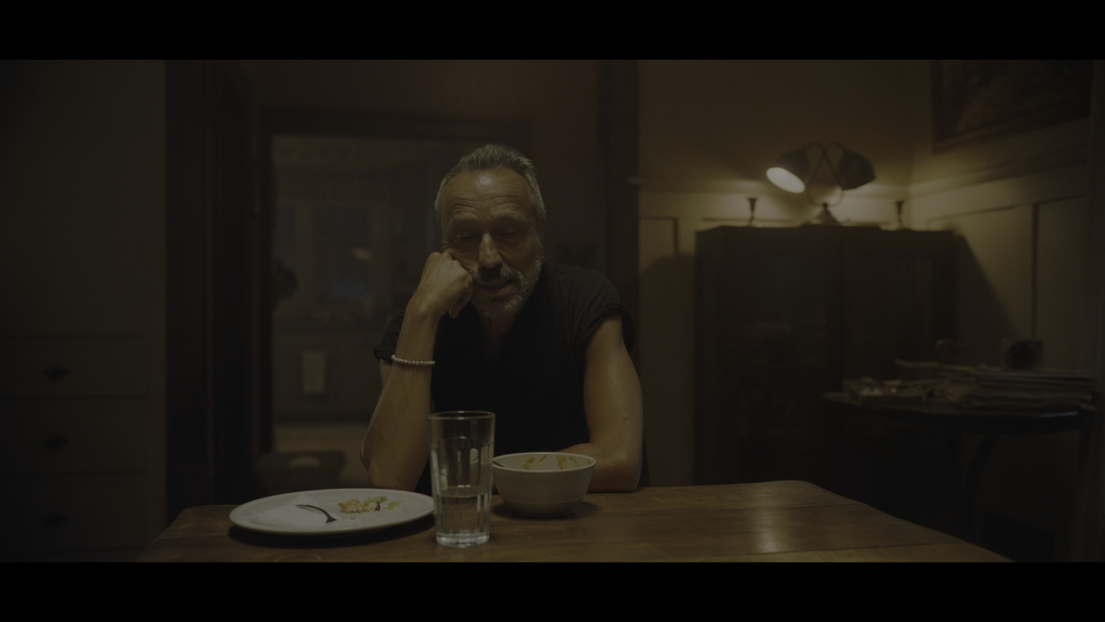 a man sitting at a table with a glass of water