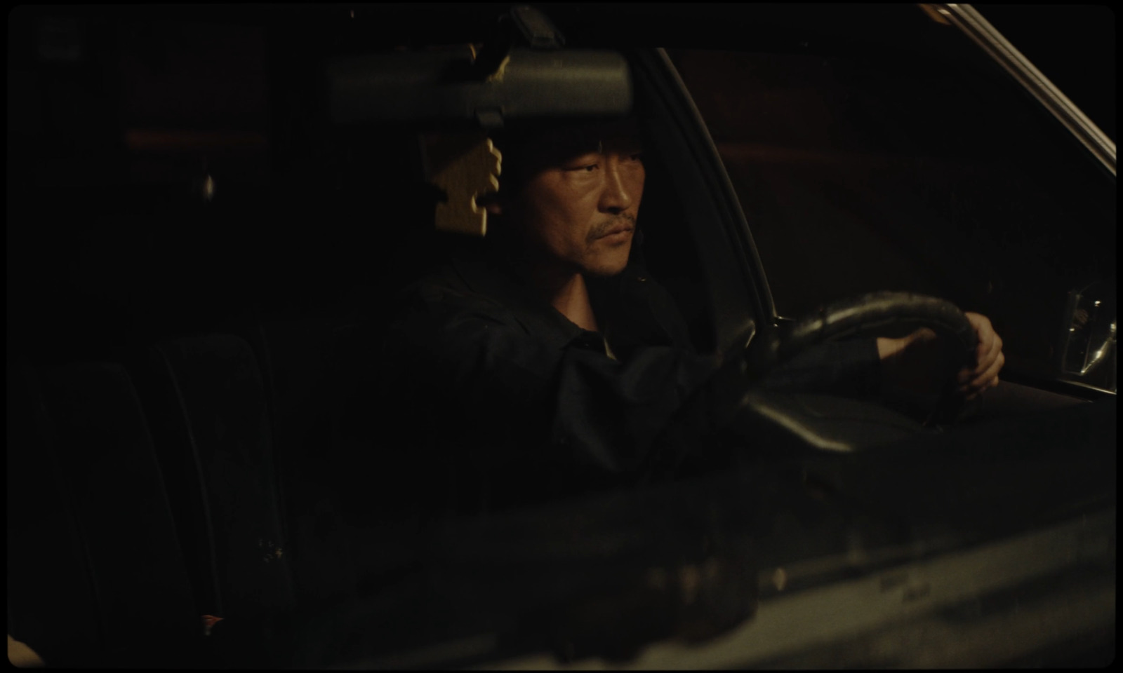 a man driving a car in the dark