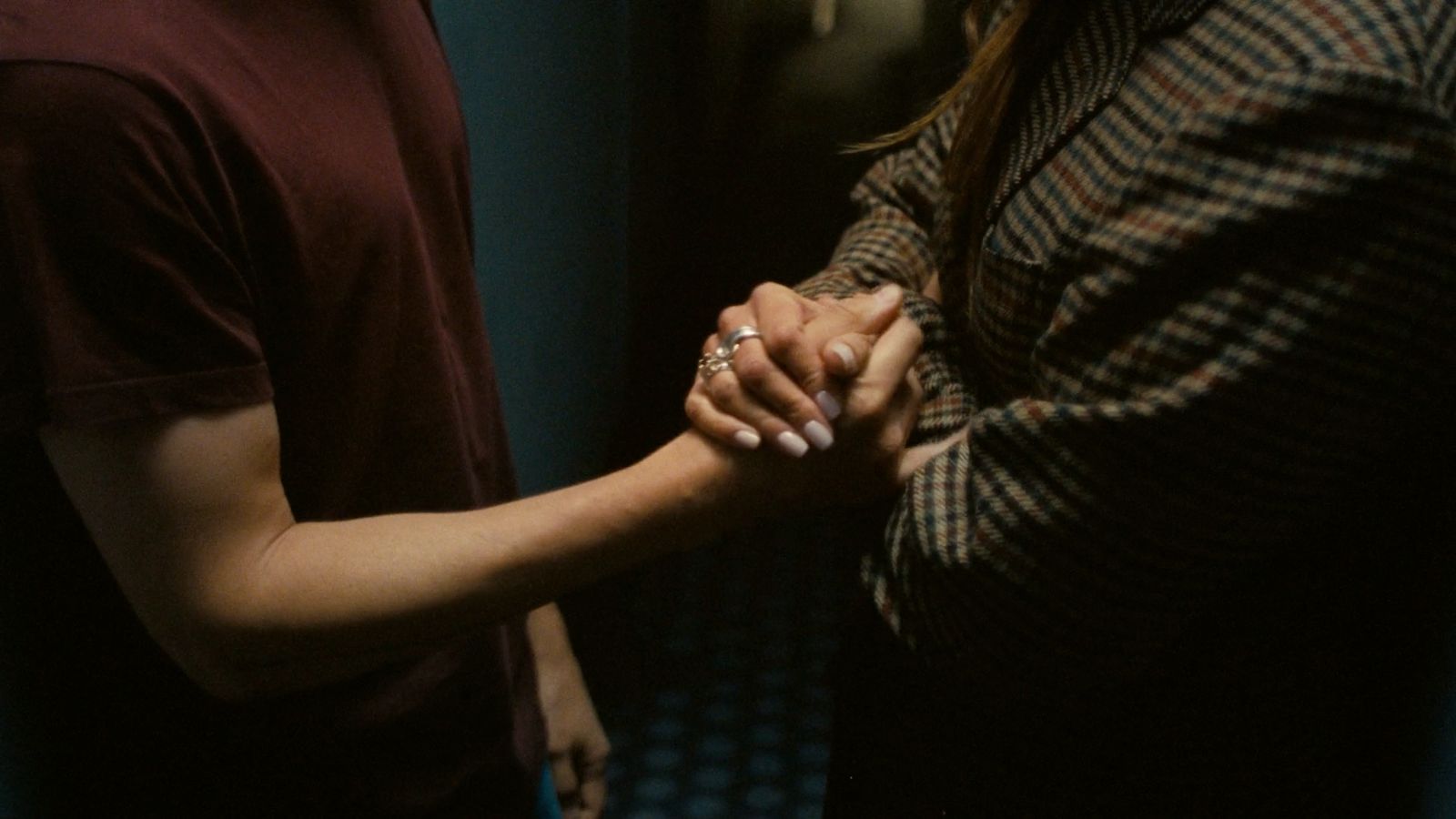 a man and a woman holding hands in a room