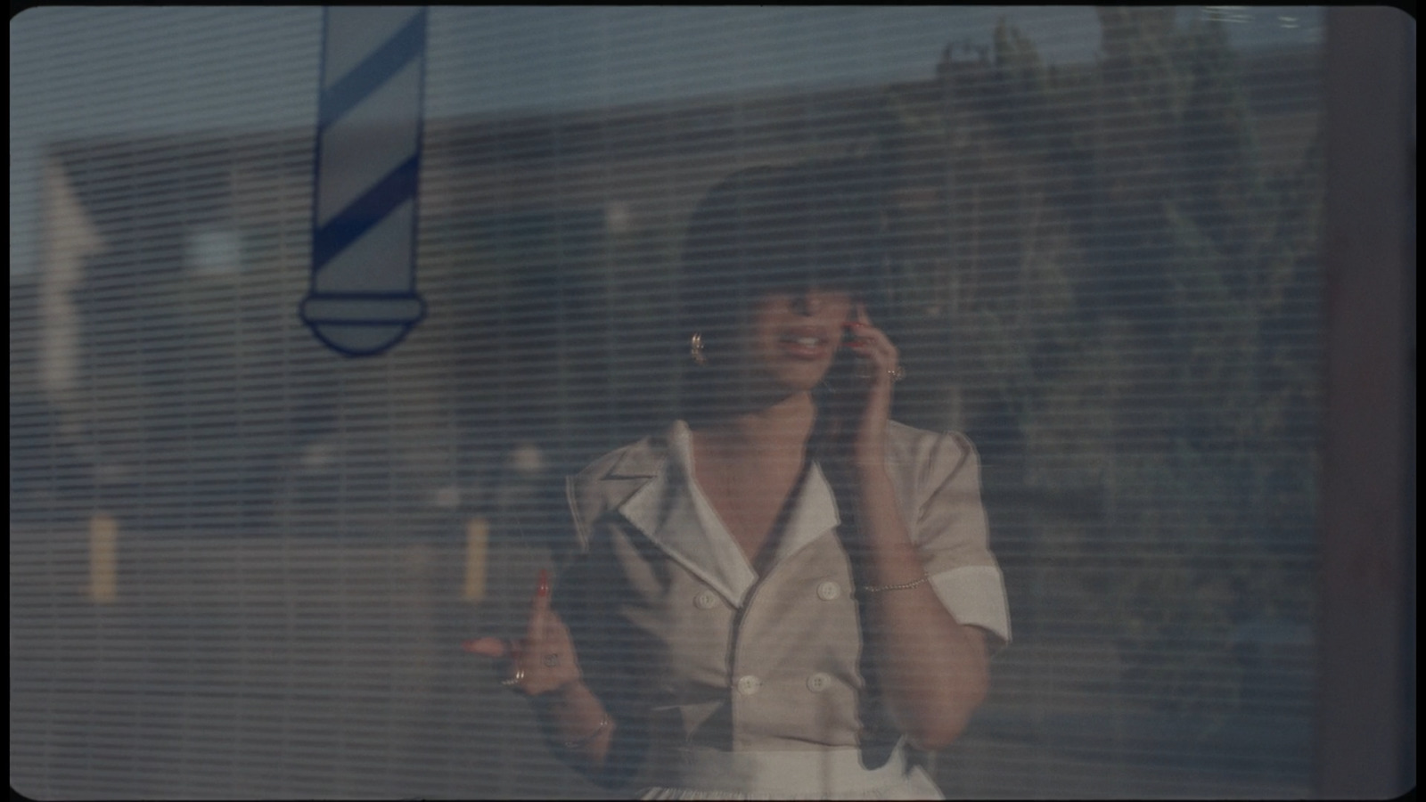 a woman talking on a cell phone in front of a window