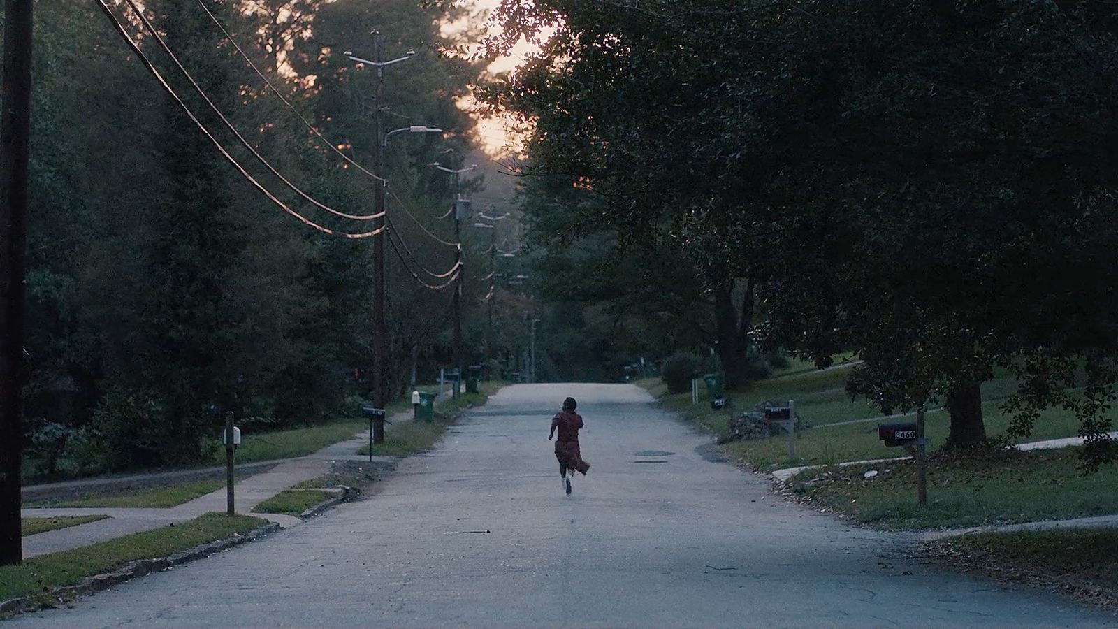 a woman walking down a street in a park