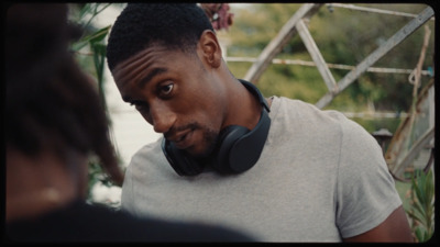 a man wearing headphones standing next to a woman