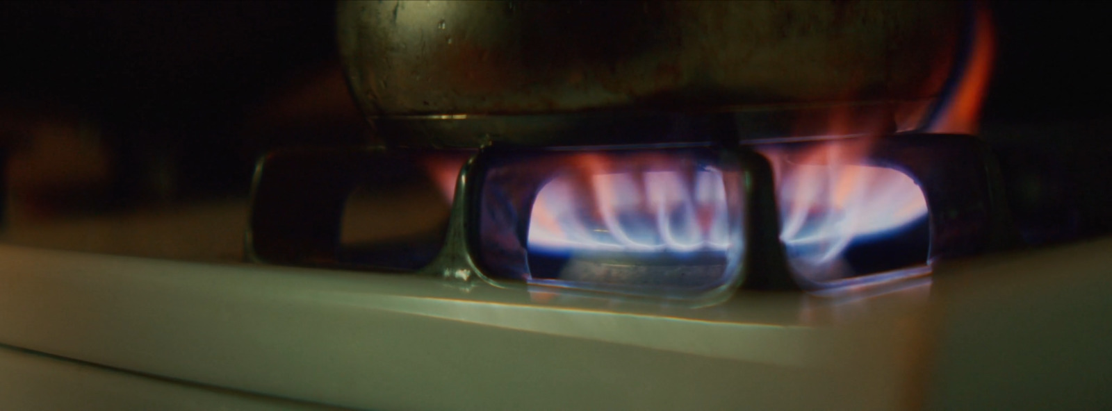 a close up of a stove with a blue flame