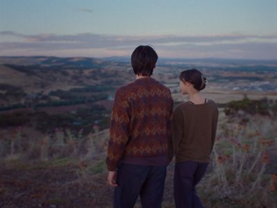 a man and a woman standing on top of a hill