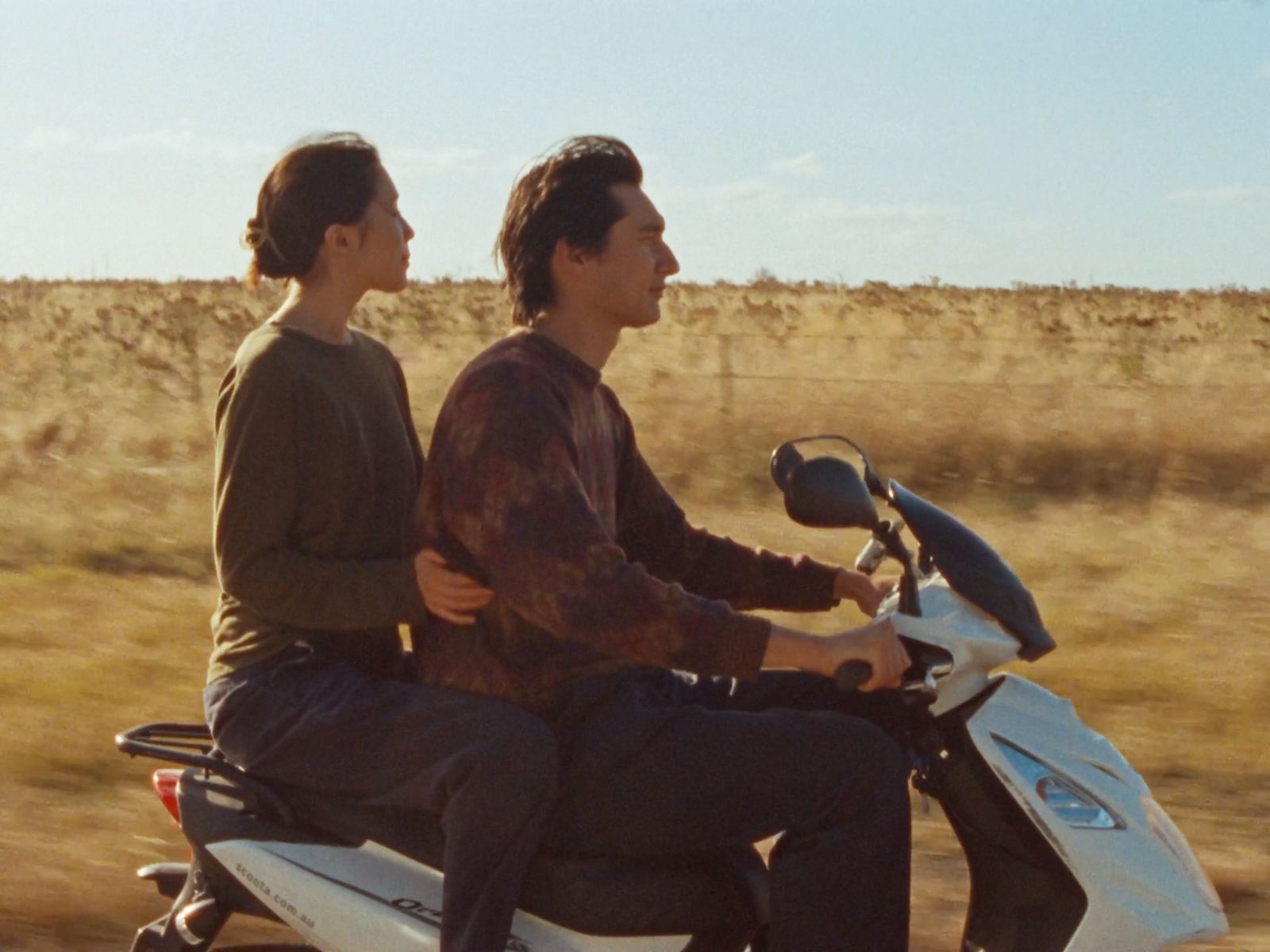 a man and a woman riding on the back of a motorcycle