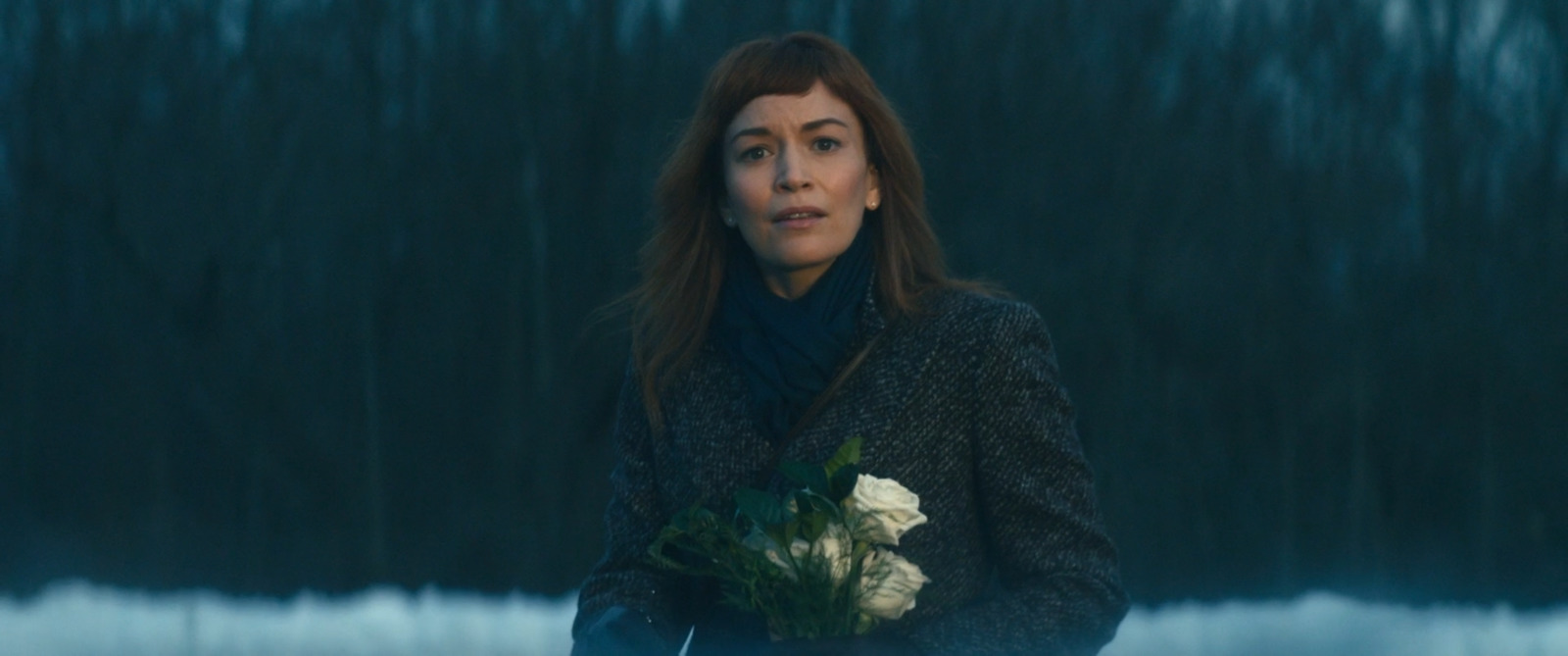 a woman holding a bouquet of flowers in her hands