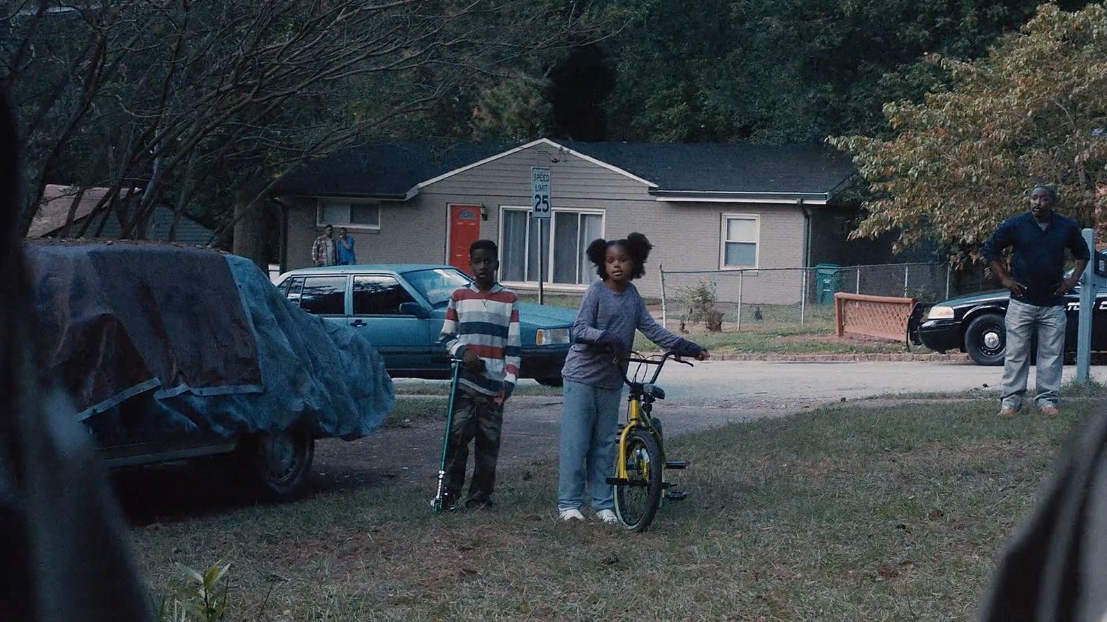 a couple of kids standing next to a bike