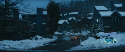 a car driving down a snow covered road at night