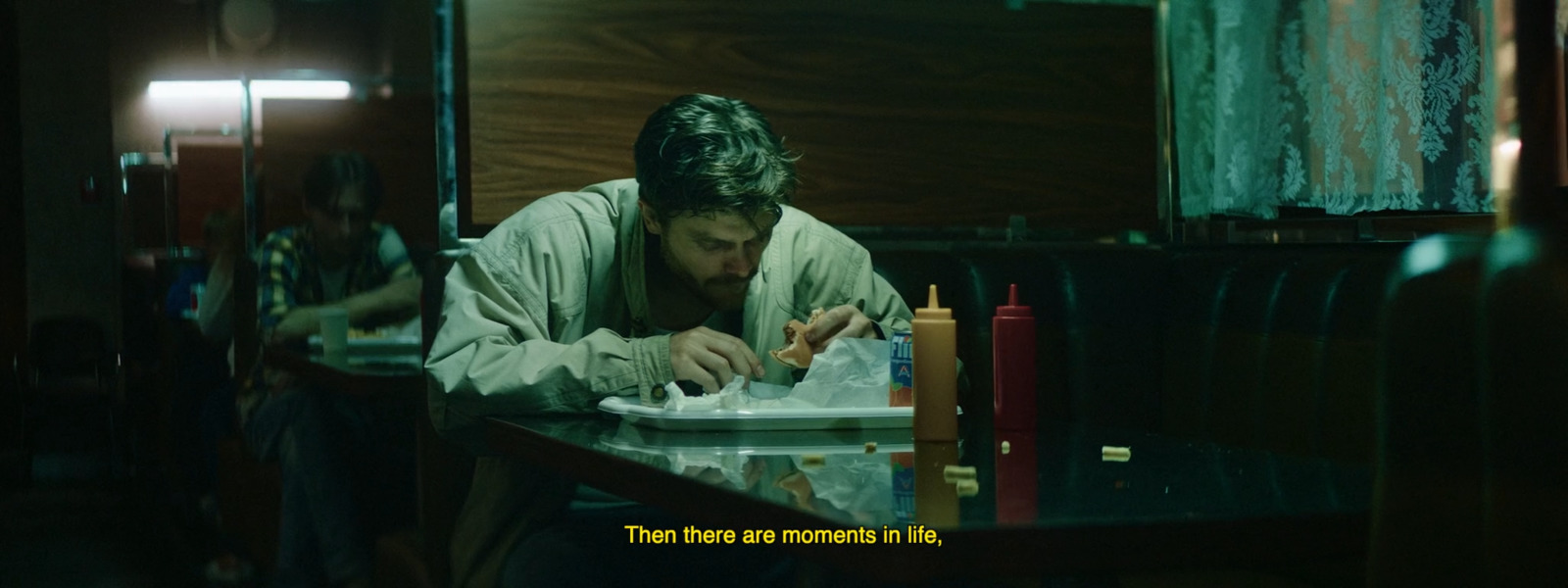 a man sitting at a table with a plate of food