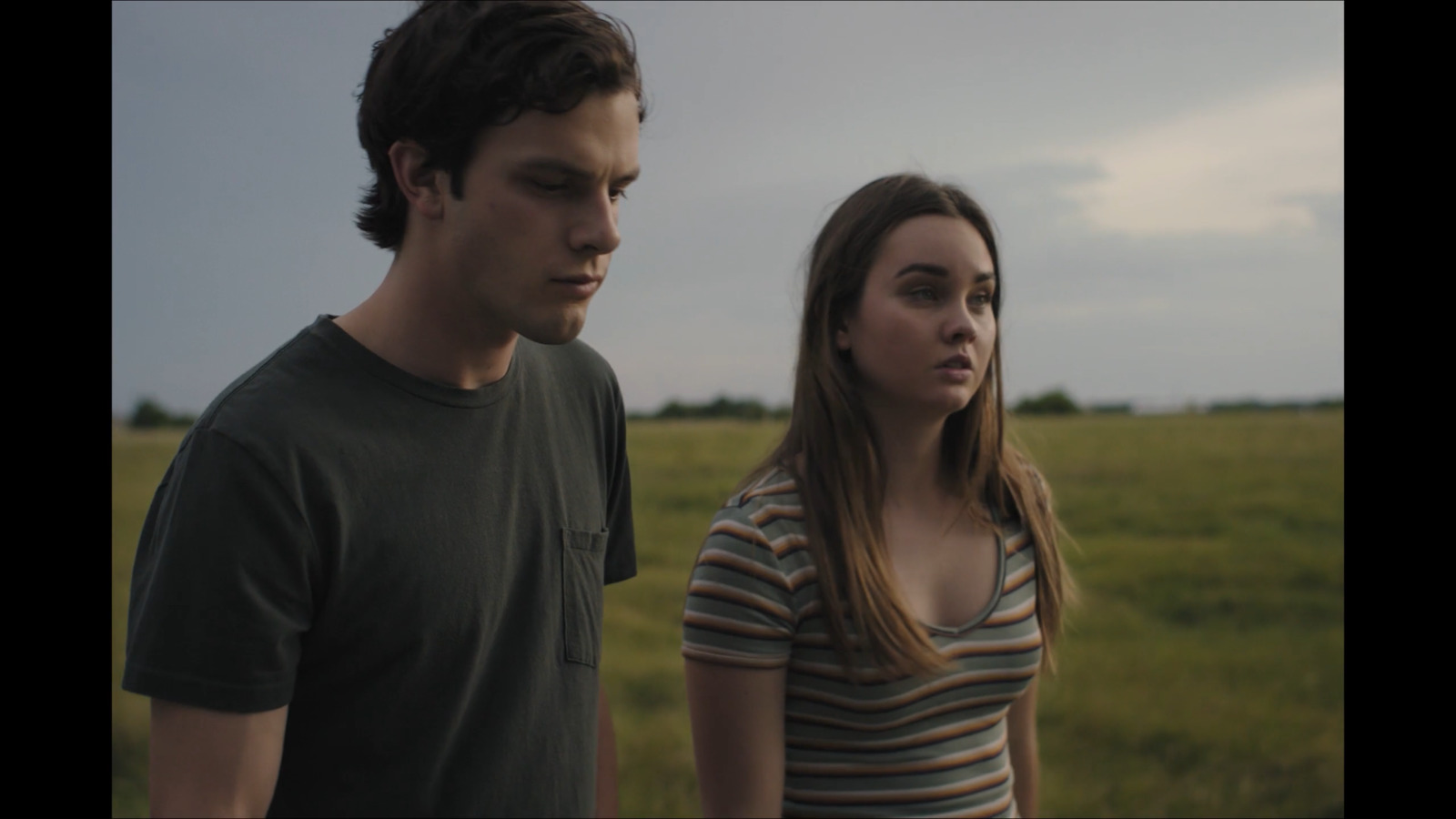 a man and a woman standing in a field