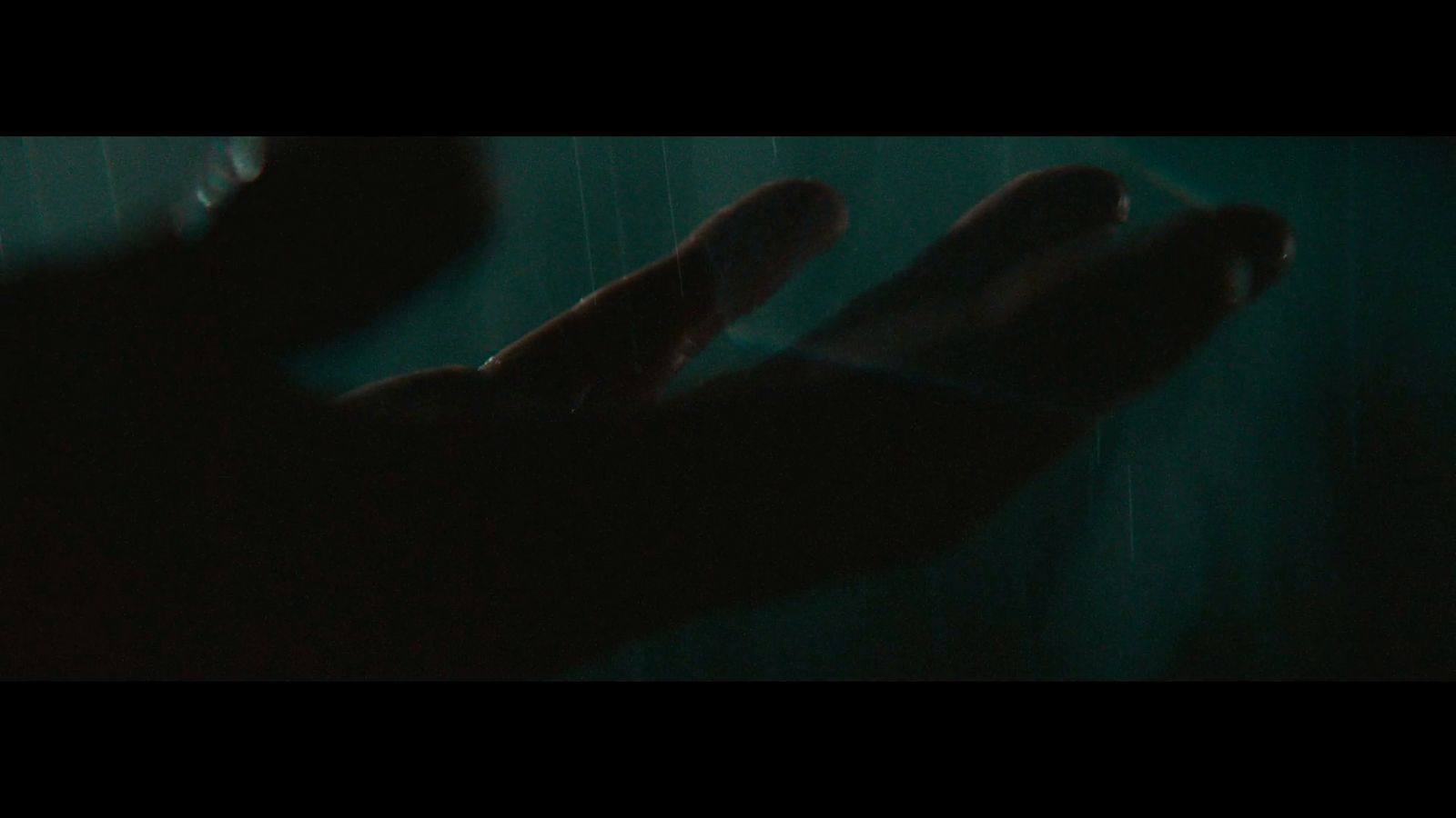 a person holding their hands out in the dark