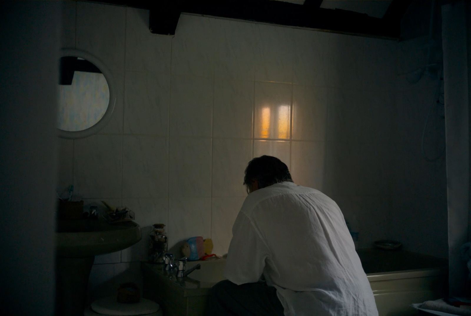 a man sitting on a toilet in a bathroom