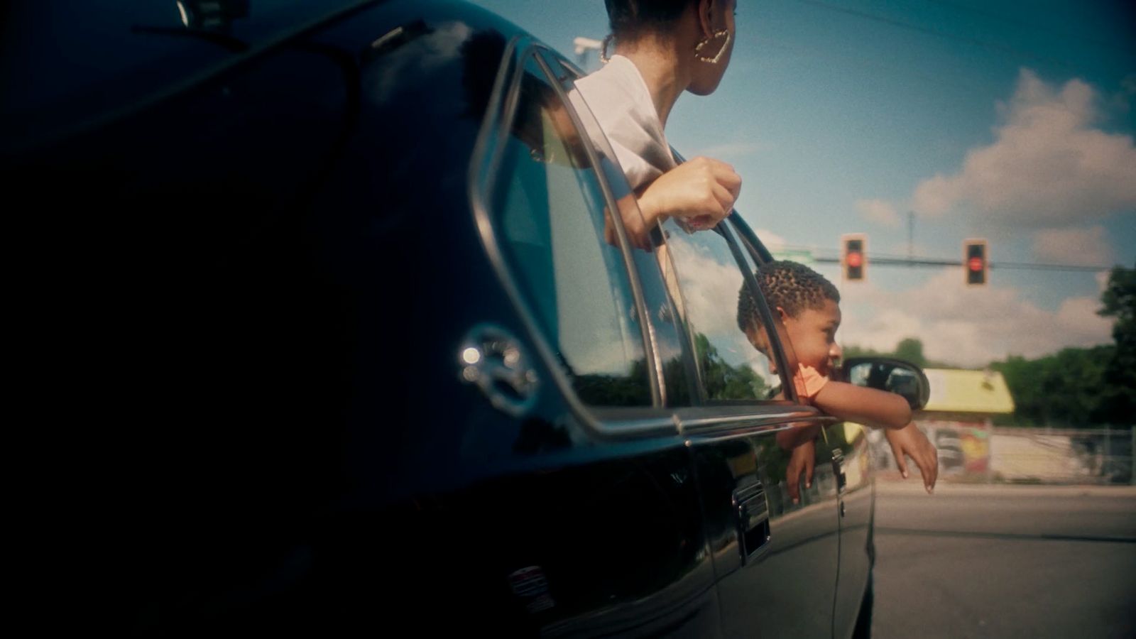 a woman holding a child's hand out of a car window