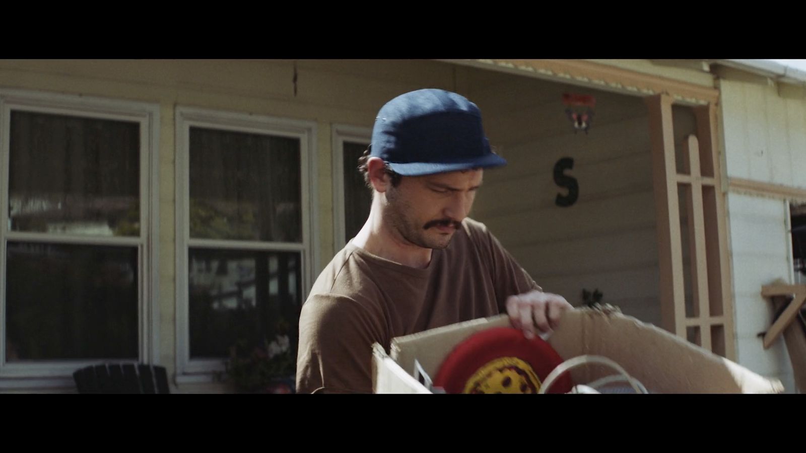 a man in a blue hat is opening a box