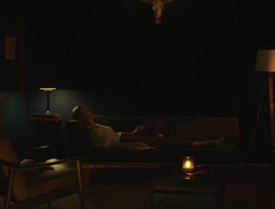 a woman laying on a couch in a dark room