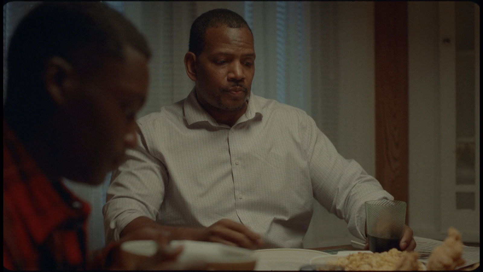 a man sitting at a table with a plate of food