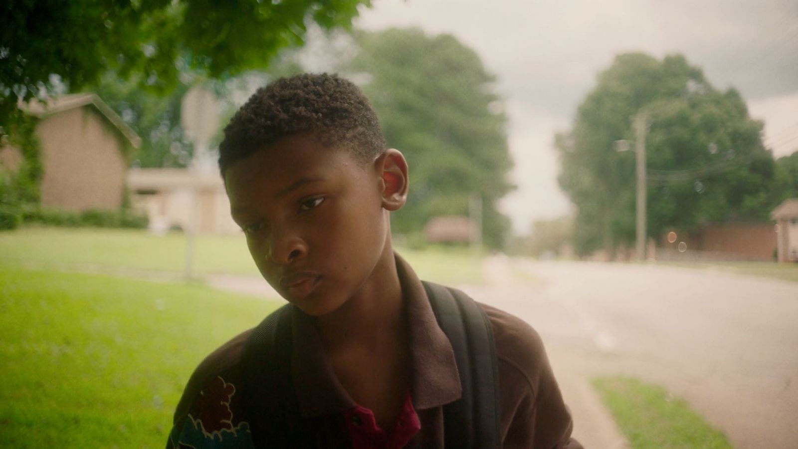 a young boy standing on the side of a road