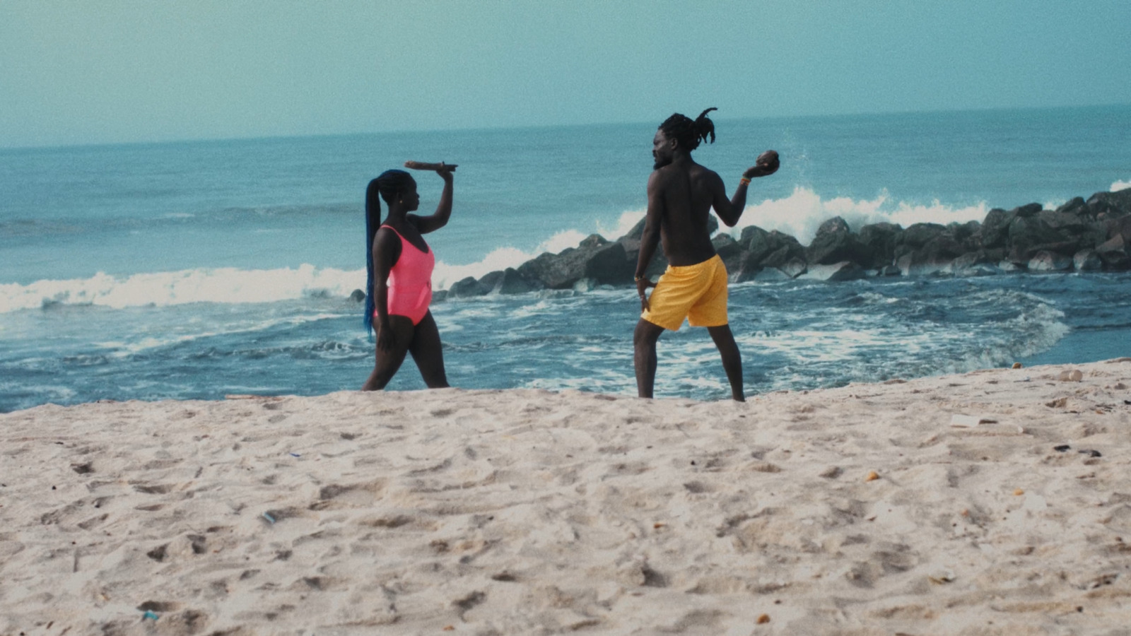 a couple of women standing on top of a sandy beach