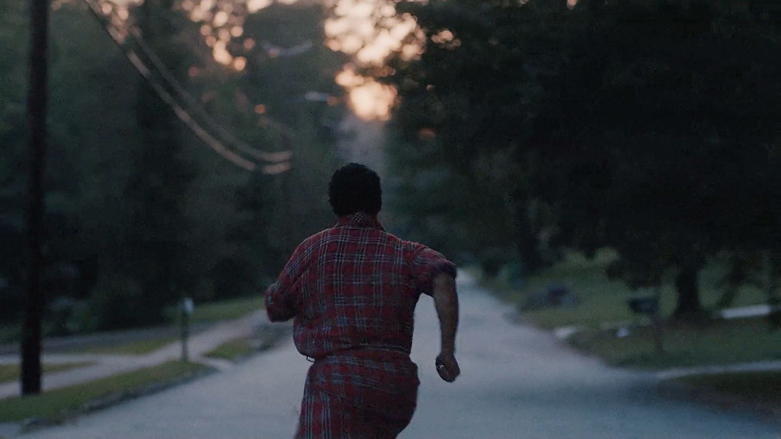 a man walking down a street with a skateboard