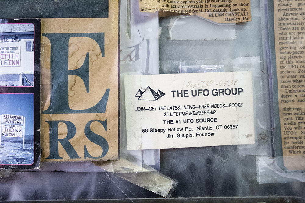 a group of papers and a cell phone on a shelf