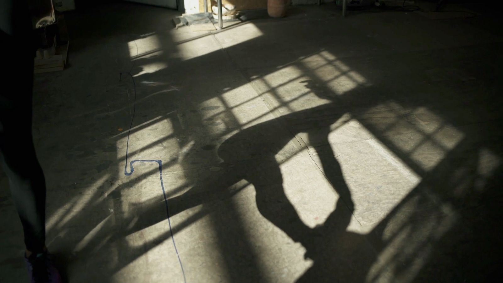 a shadow of a person on a skateboard in a room