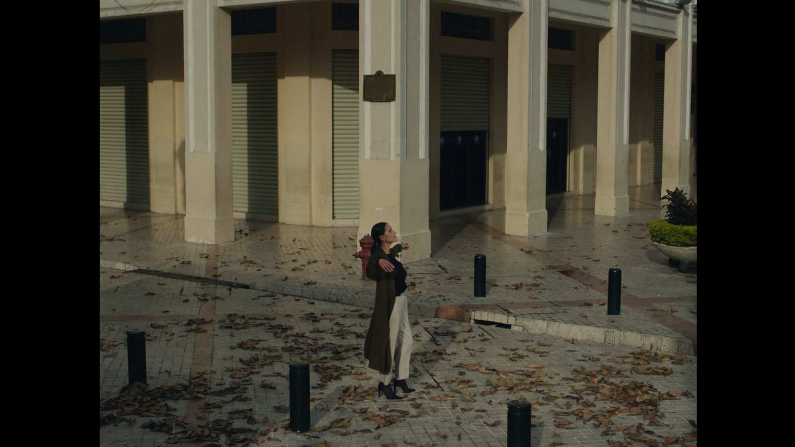 a woman standing in front of a building holding a cell phone