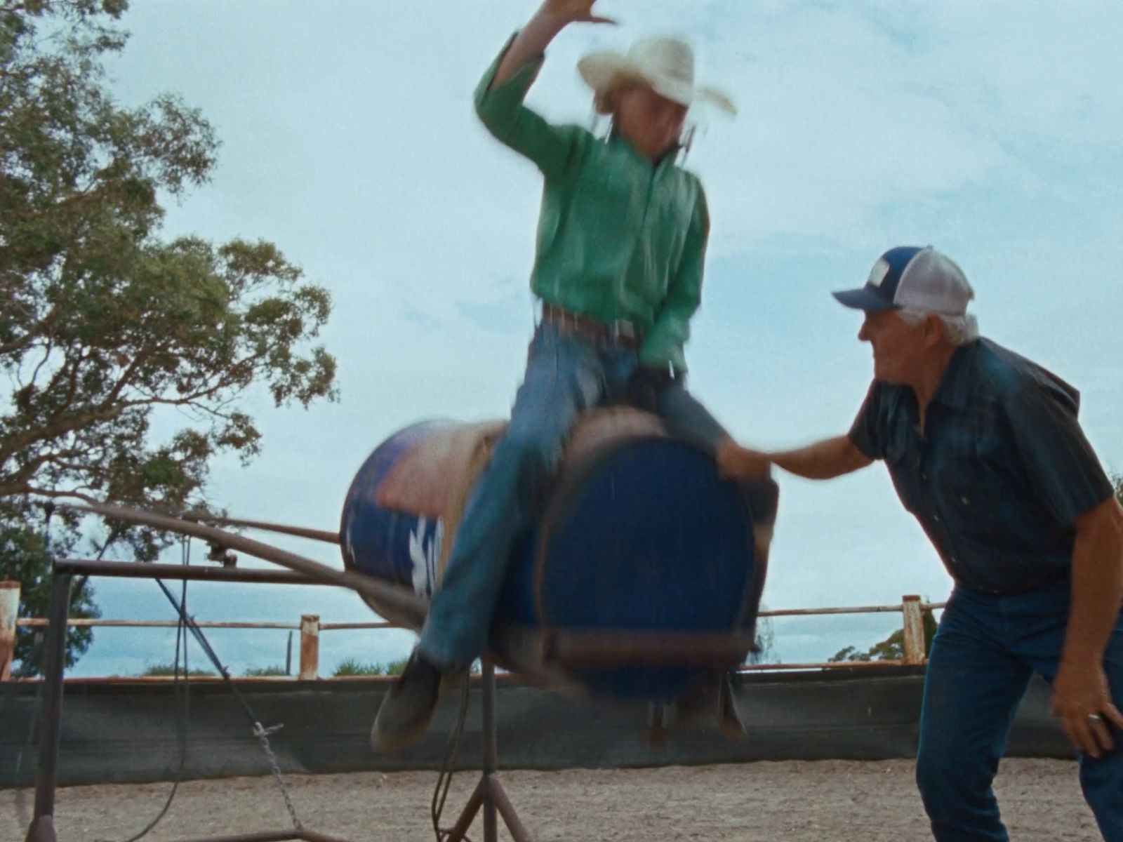 a man riding on the back of a blue barrel