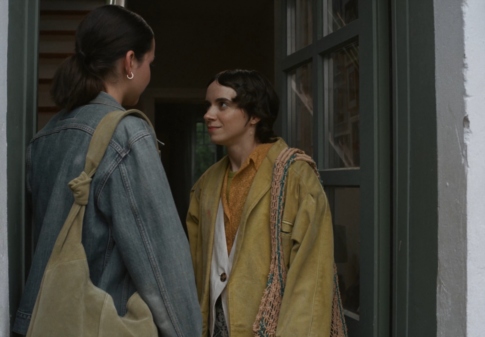 two women standing in a doorway talking to each other