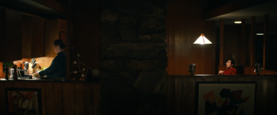 a woman sitting at a bar in a dimly lit room