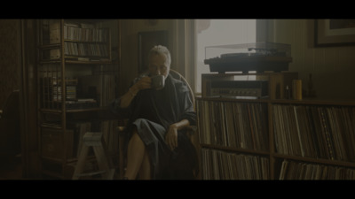 a man sitting in a chair drinking from a cup