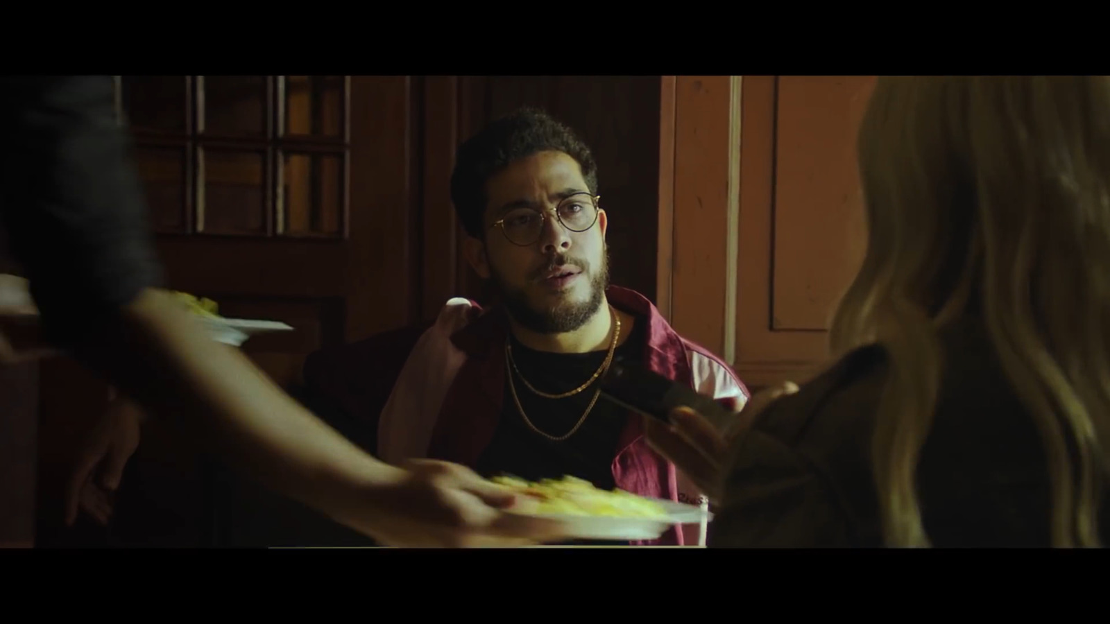 a man in a red shirt is holding a plate of food