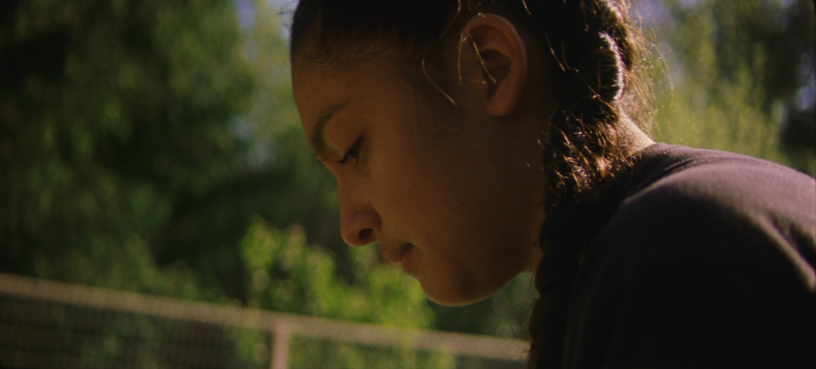 a young girl is looking down at her cell phone