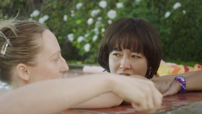 a couple of women sitting next to each other in a pool