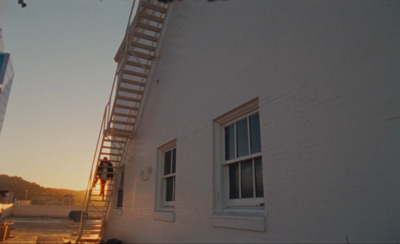 a man climbing up a ladder to a building