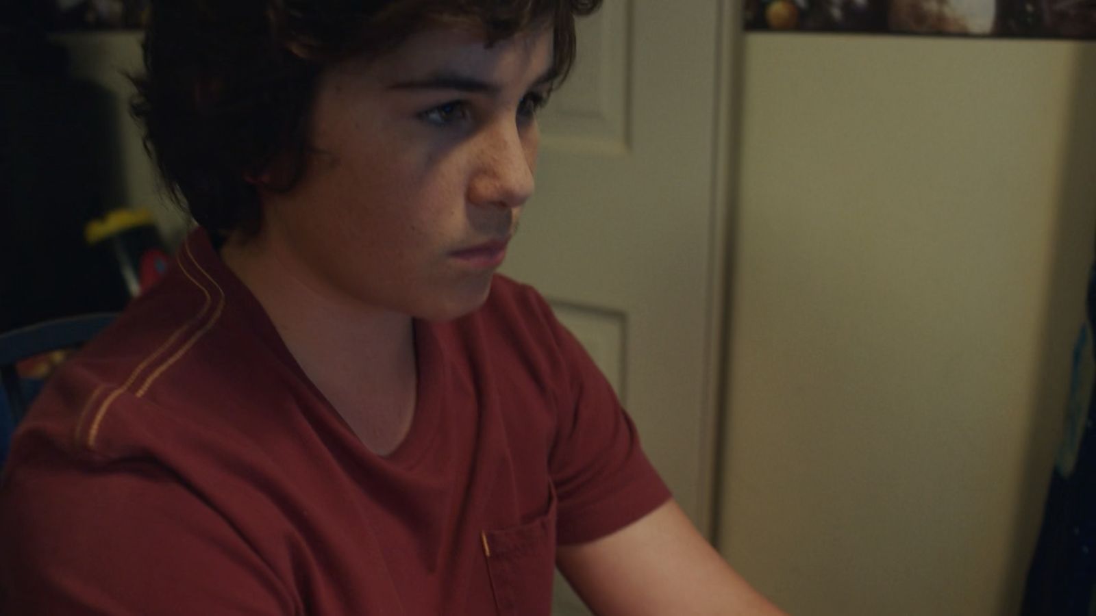 a young man sitting in front of a laptop computer