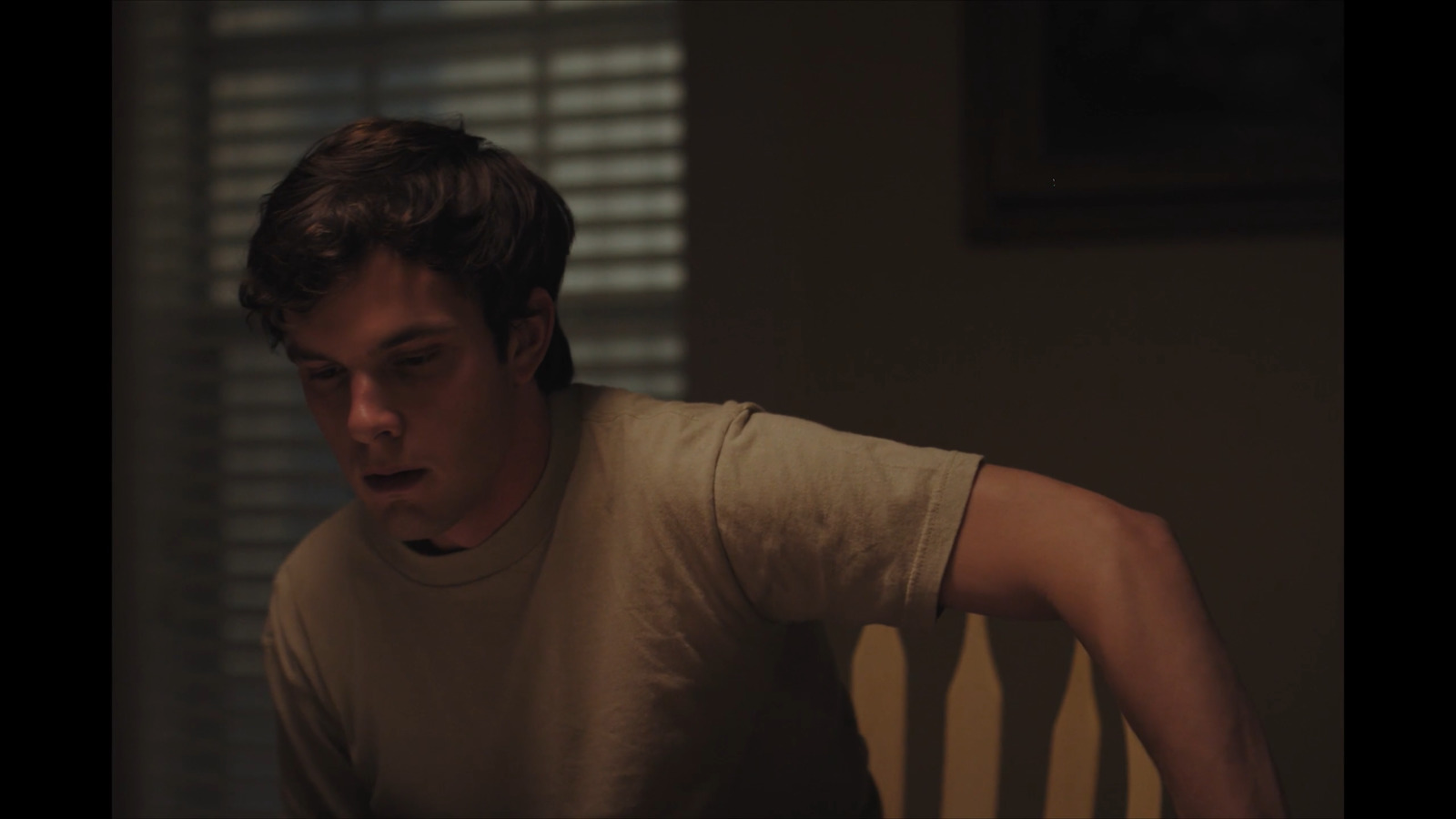 a man sitting in a chair looking at his cell phone